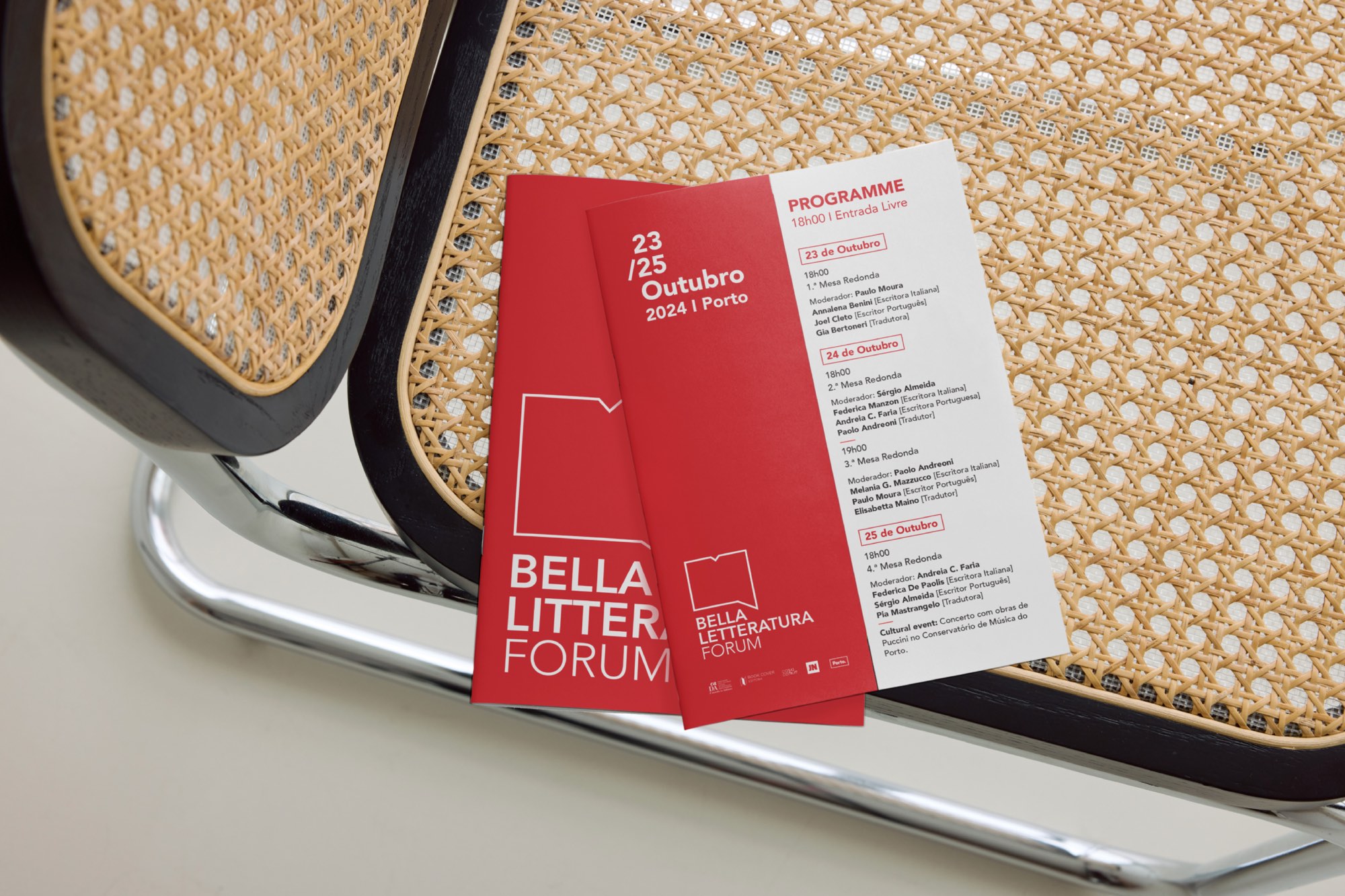 Dépliants rouges du programme posés sur l’assise cannée d’une chaise.