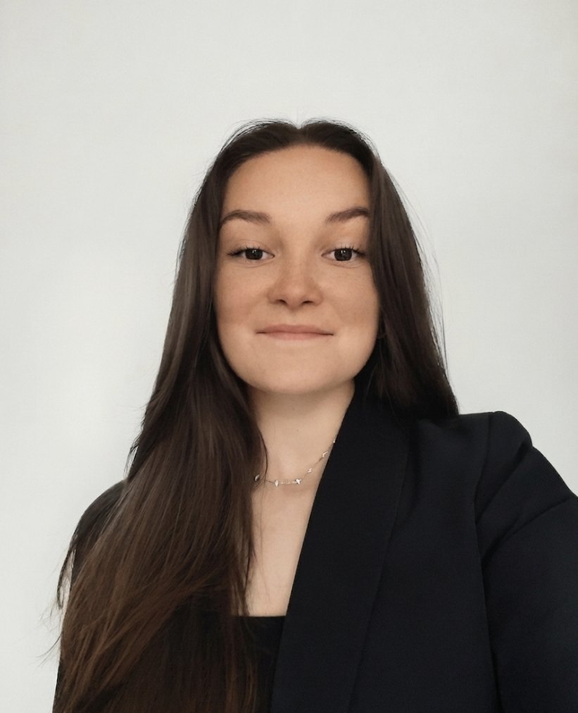 Portrait de Clémentine Gicquiaud, veste sombre, cheveux longs, devant un mur clair.