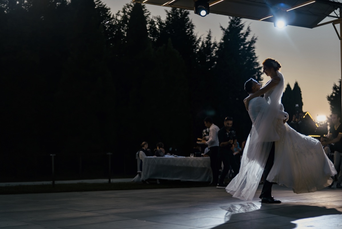 Un couple ouvre le bal en extérieur, la robe emportée par le mouvement.