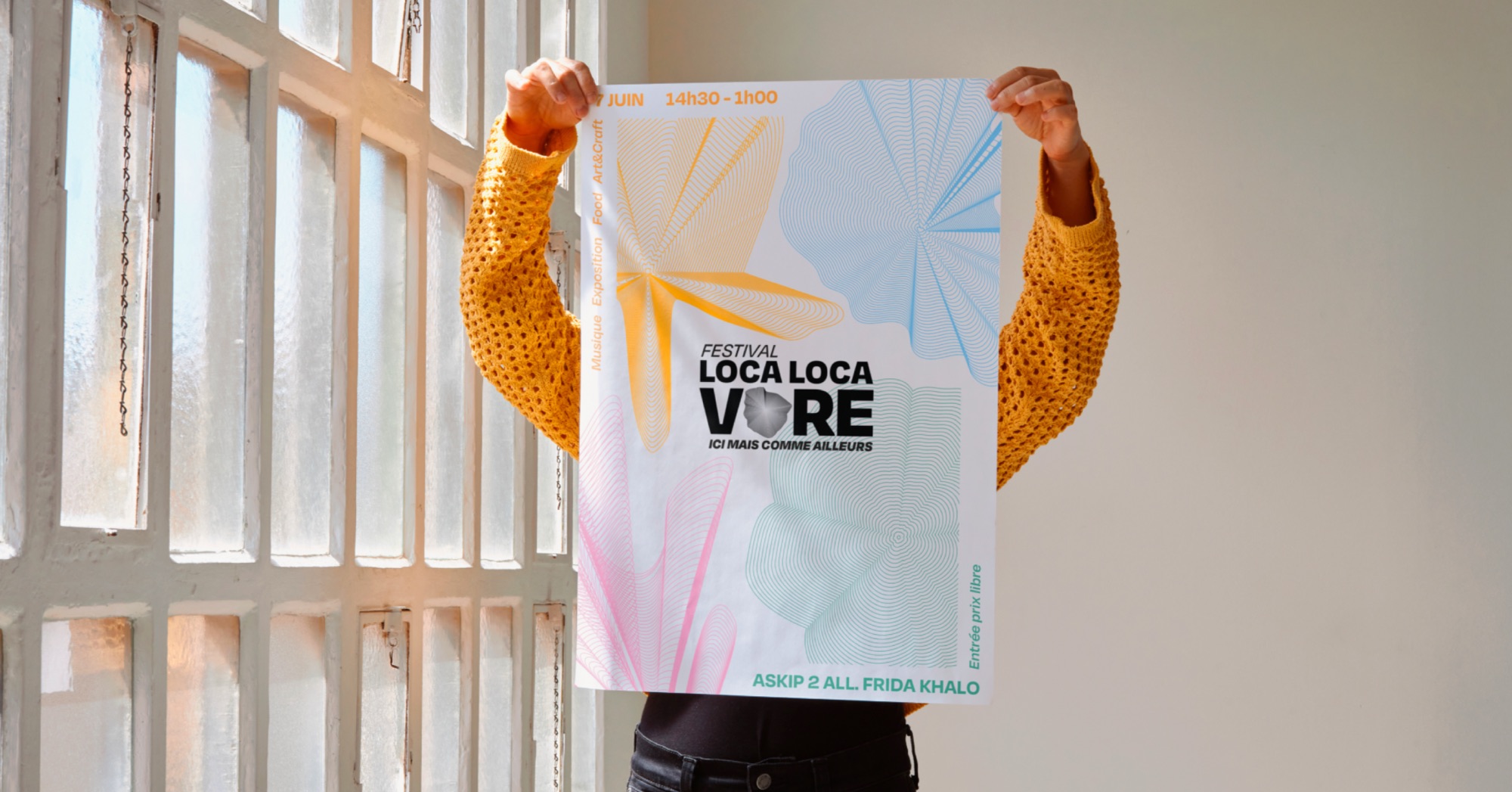 Affiche du festival Localocavore tenue à bout de bras devant une verrière.