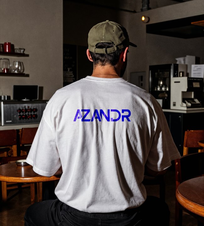 Tee-shirt blanc floqué dans le dos, porté dans un café.