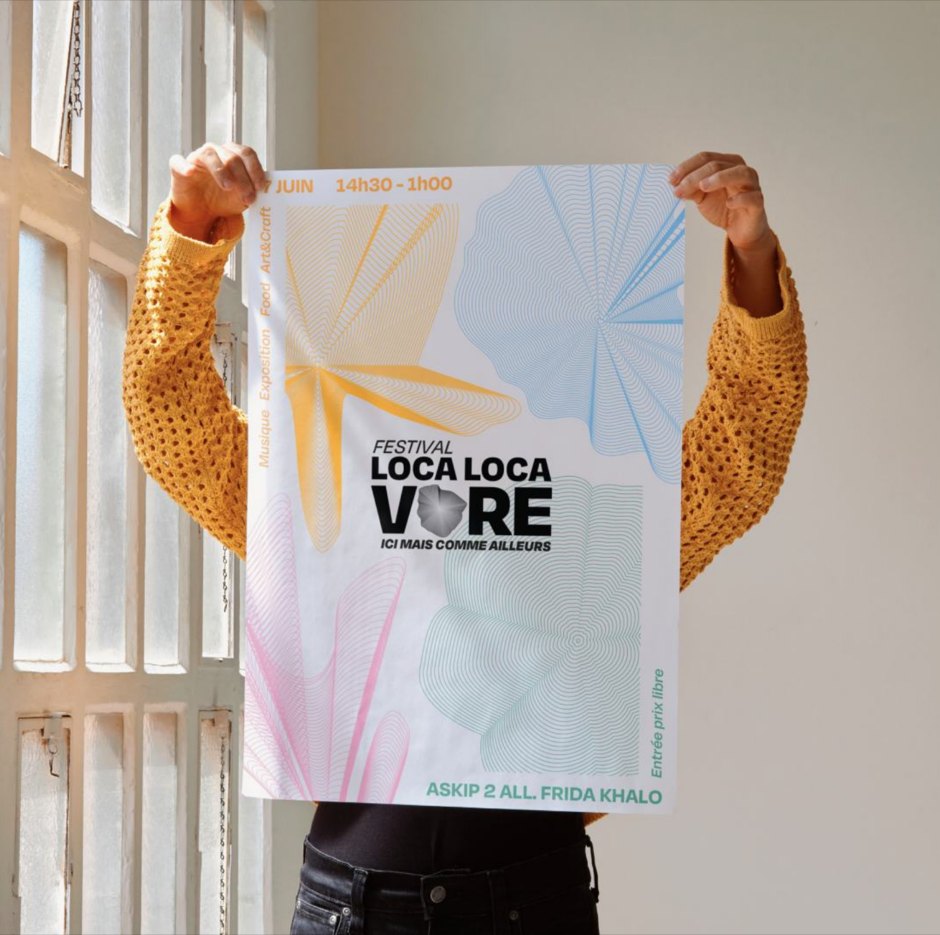 L’affiche du festival tenue à bout de bras devant une fenêtre.